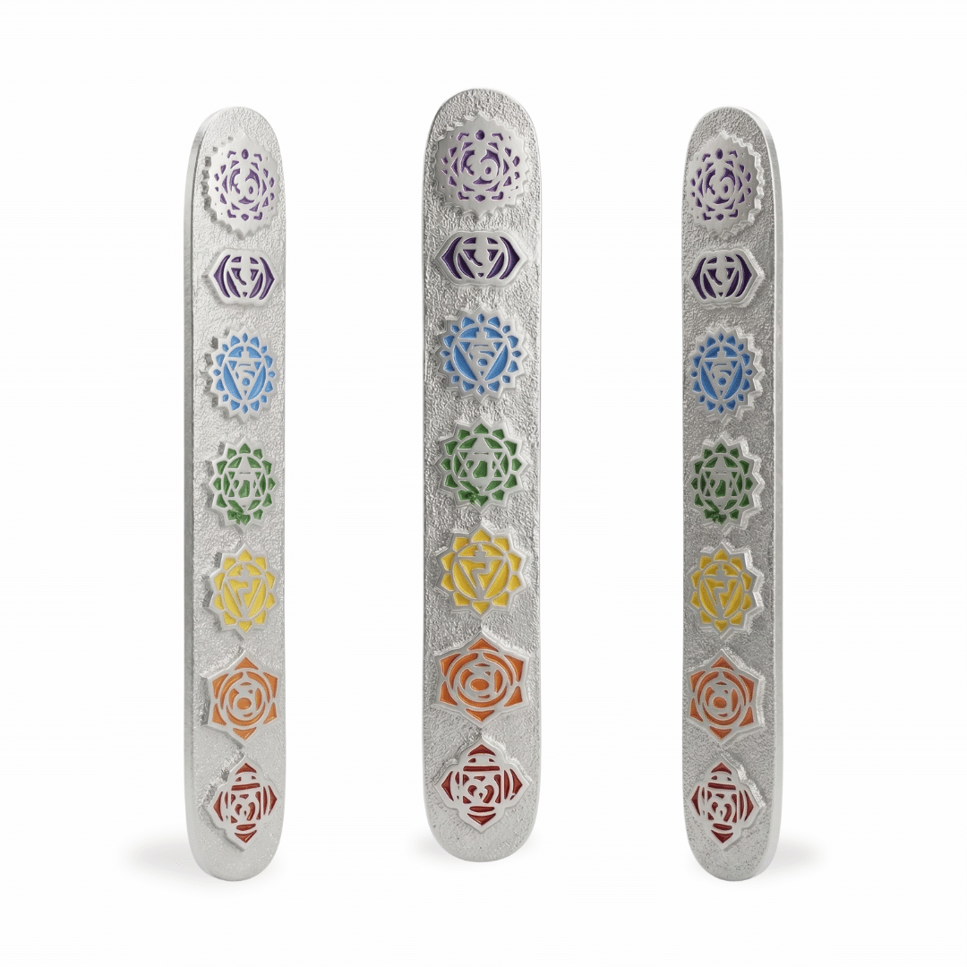 porta inciensos de metal plateado con textura rugosa y símbolos de los 7 chakras esmaltados en colores, mostrados en vista frontal y laterales sobre fondo blanco puro.
