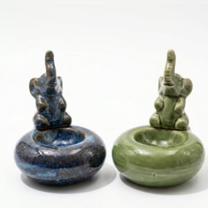 Porta sahumerios de cerámica circular con figura de elefante de la suerte, colores azul moteado y verde esmaltado, medidas 8,5x8,5 cm.