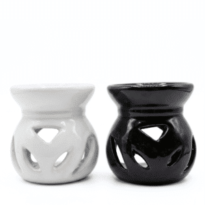 Dos difusores de aromas de cerámica esmaltada en color blanco y negro con diseño calado de hojas sobre fondo blanco.
