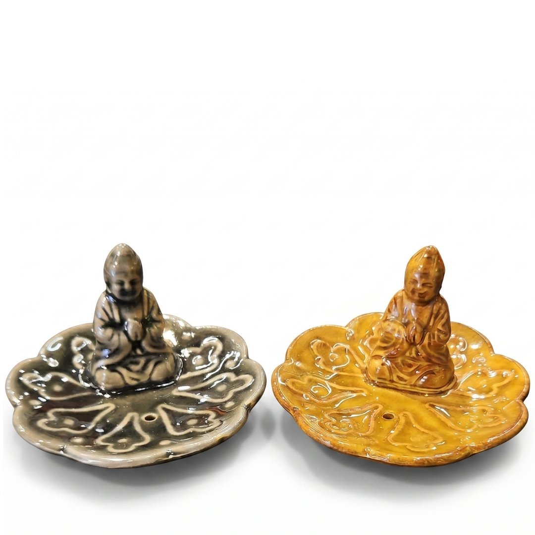 Porta sahumerios de cerámica con figura de Buda sentado en el centro de una flor de loto, colores gris piedra y ocre esmaltado, 11x11 cm.