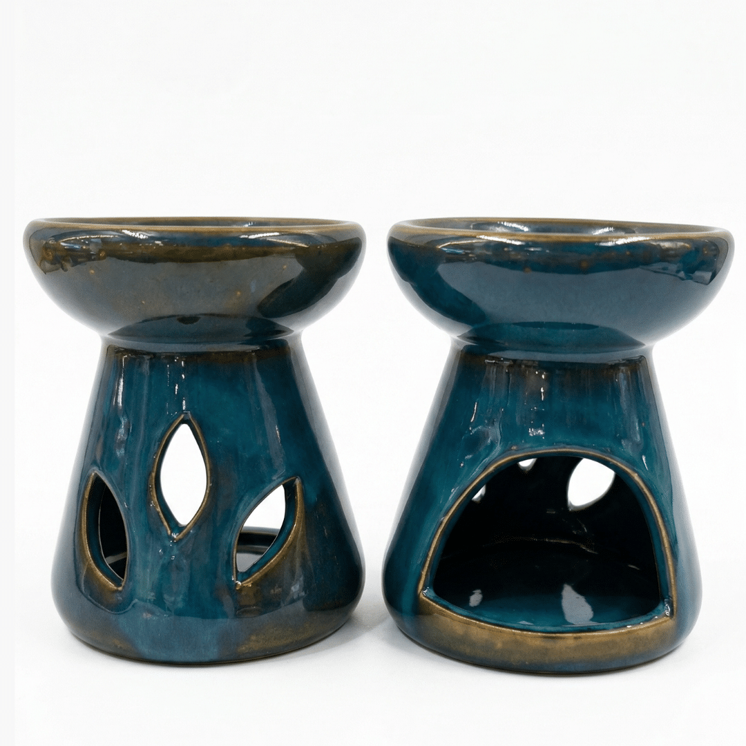 Dos difusores de aromas de cerámica esmaltada en color azul petróleo con detalles en bordes color bronce y calados de gota sobre fondo blanco.