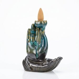 Quemador de incienso cascada de humo en cerámica esmaltada azul y negra con diseño de Mano de Buda sosteniendo una flor de Loto, con un cono de incienso encendido.